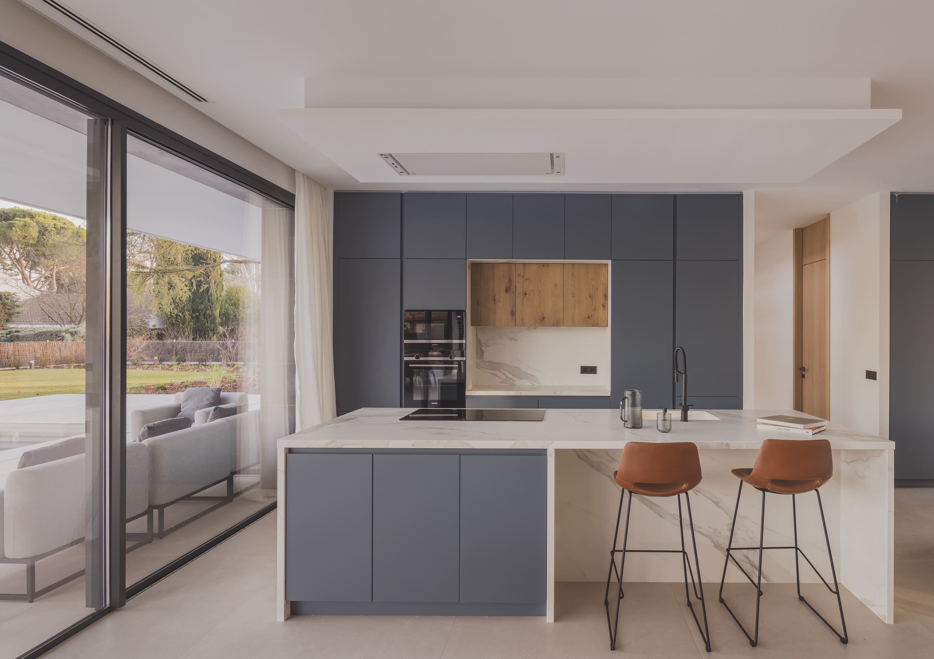 Cocina con muebles en tonos azules y encimera de mármol