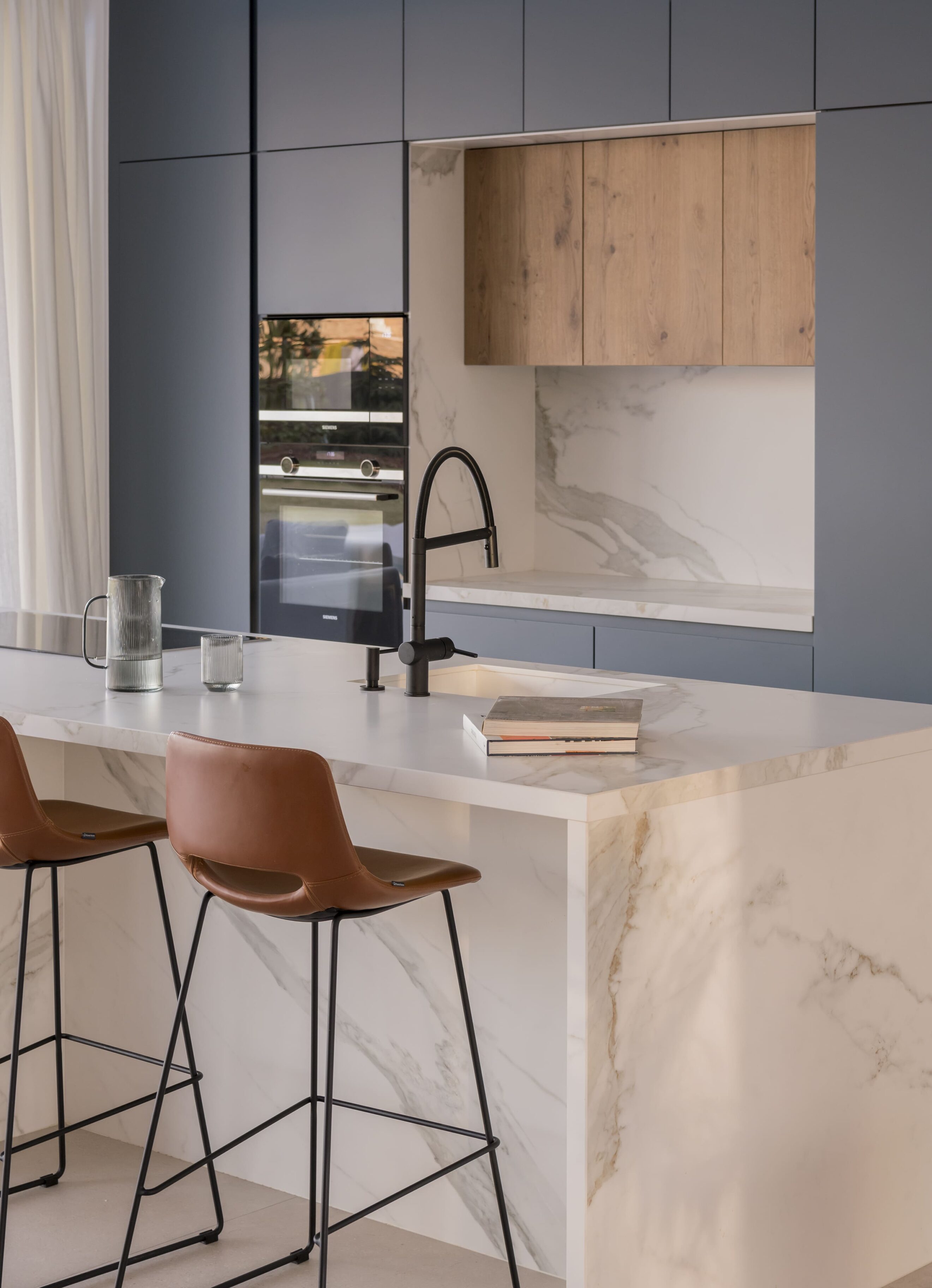 Cocina moderna con encimera de mármol y muebles en colores azul y madera