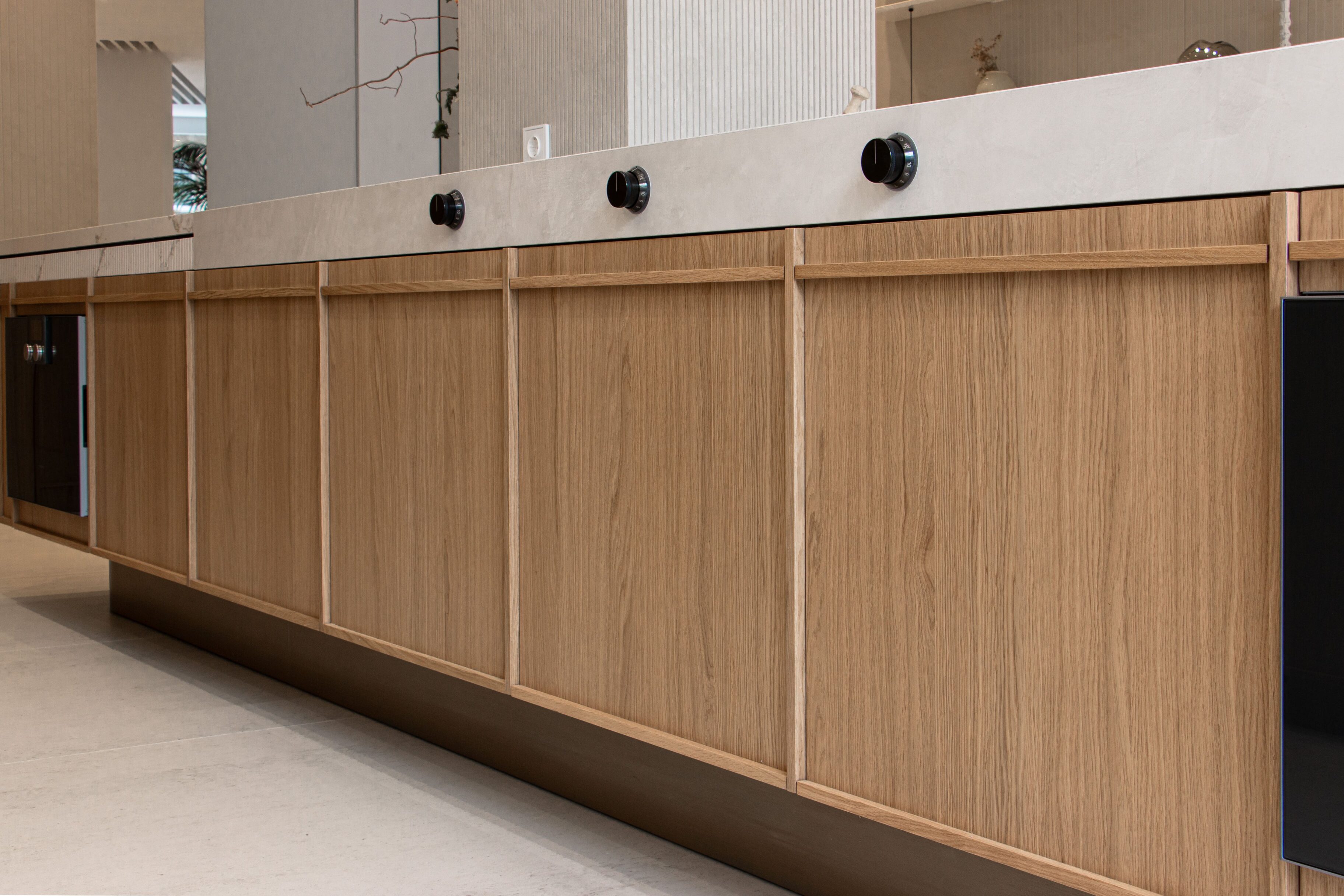 Muebles de cocina de madera clara con tiradores en color negro en un entorno moderno