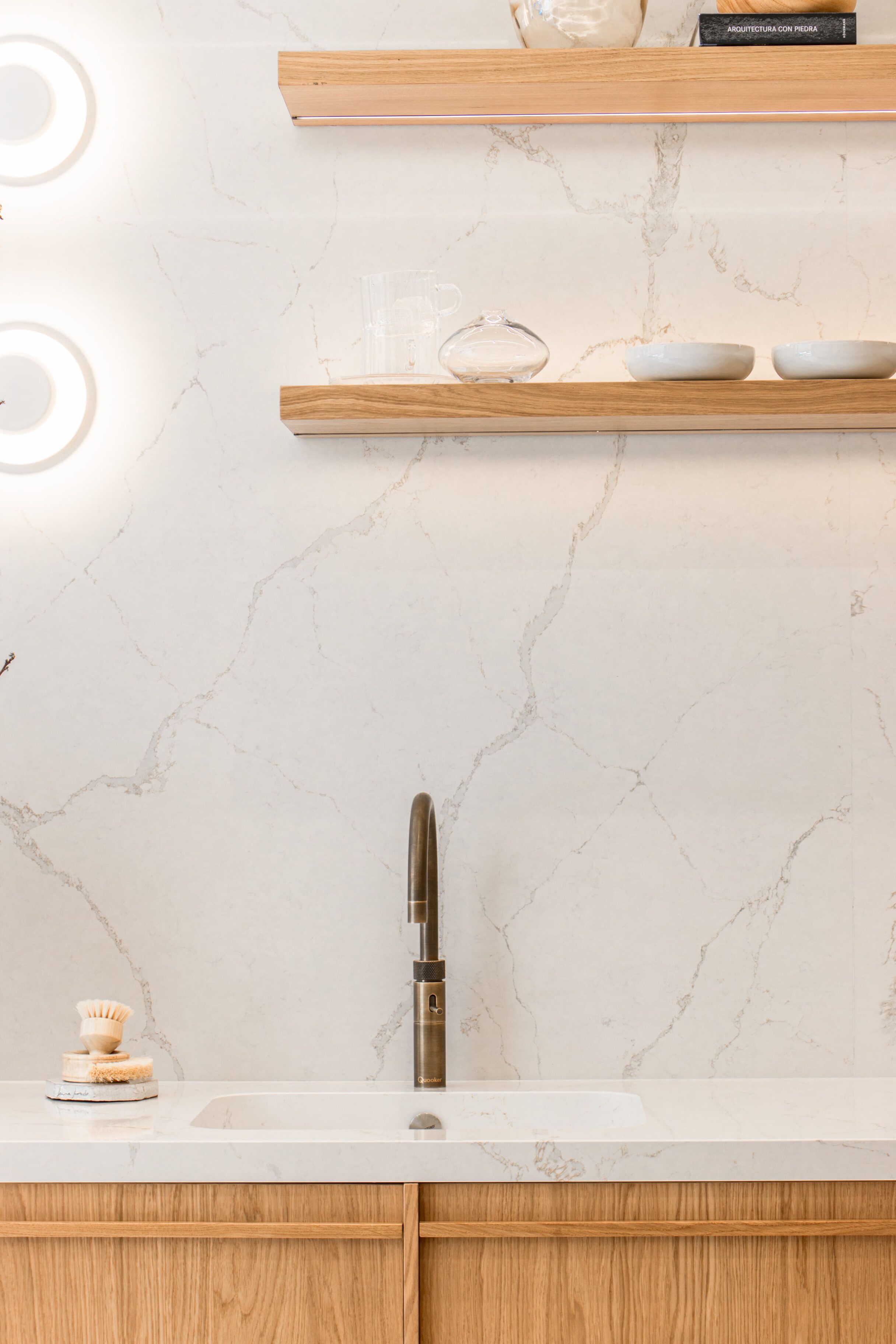 Fregadero con grifo moderno y estantes de madera en cocina