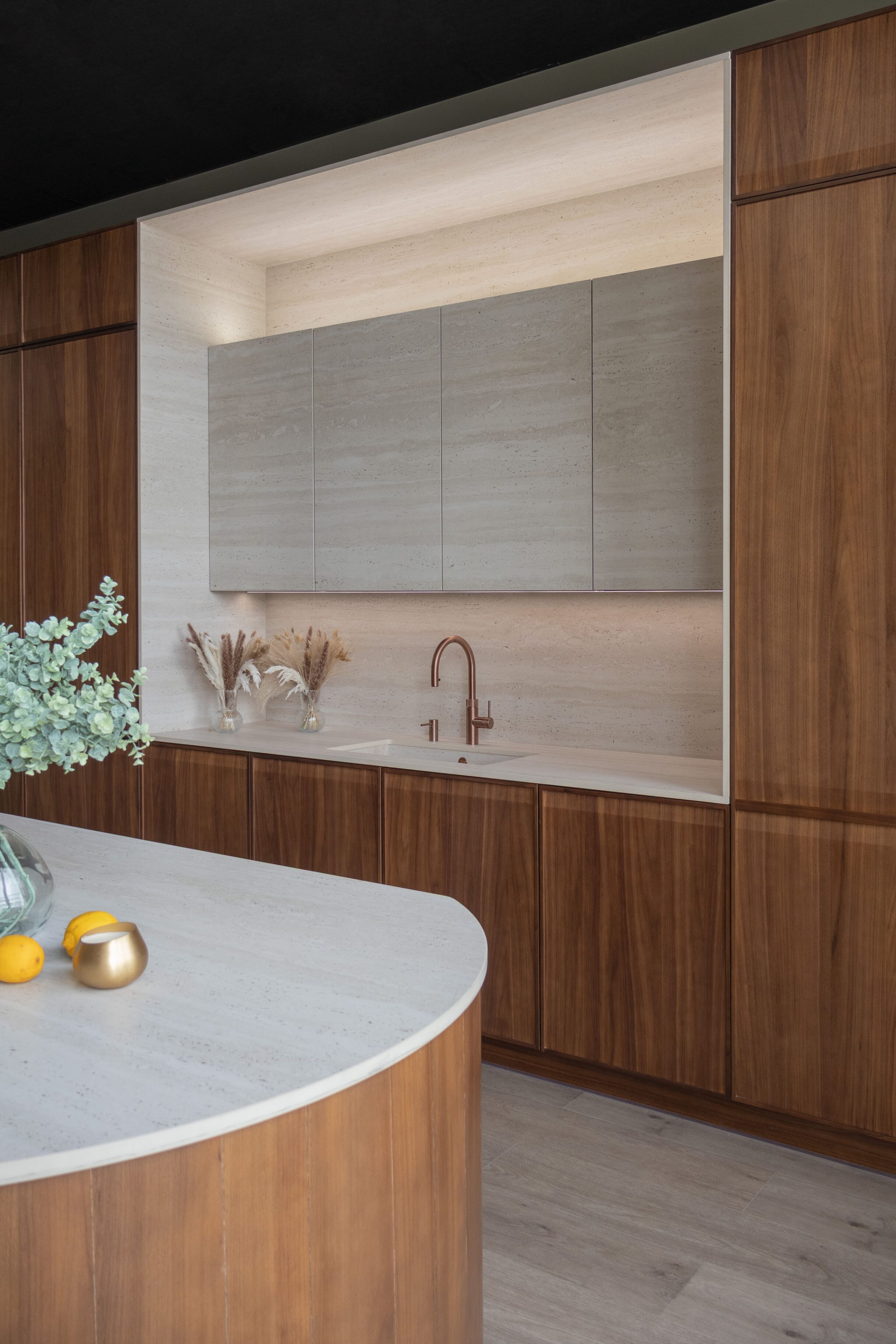 Cocina moderna con muebles de madera y encimera clara, con iluminación suave
