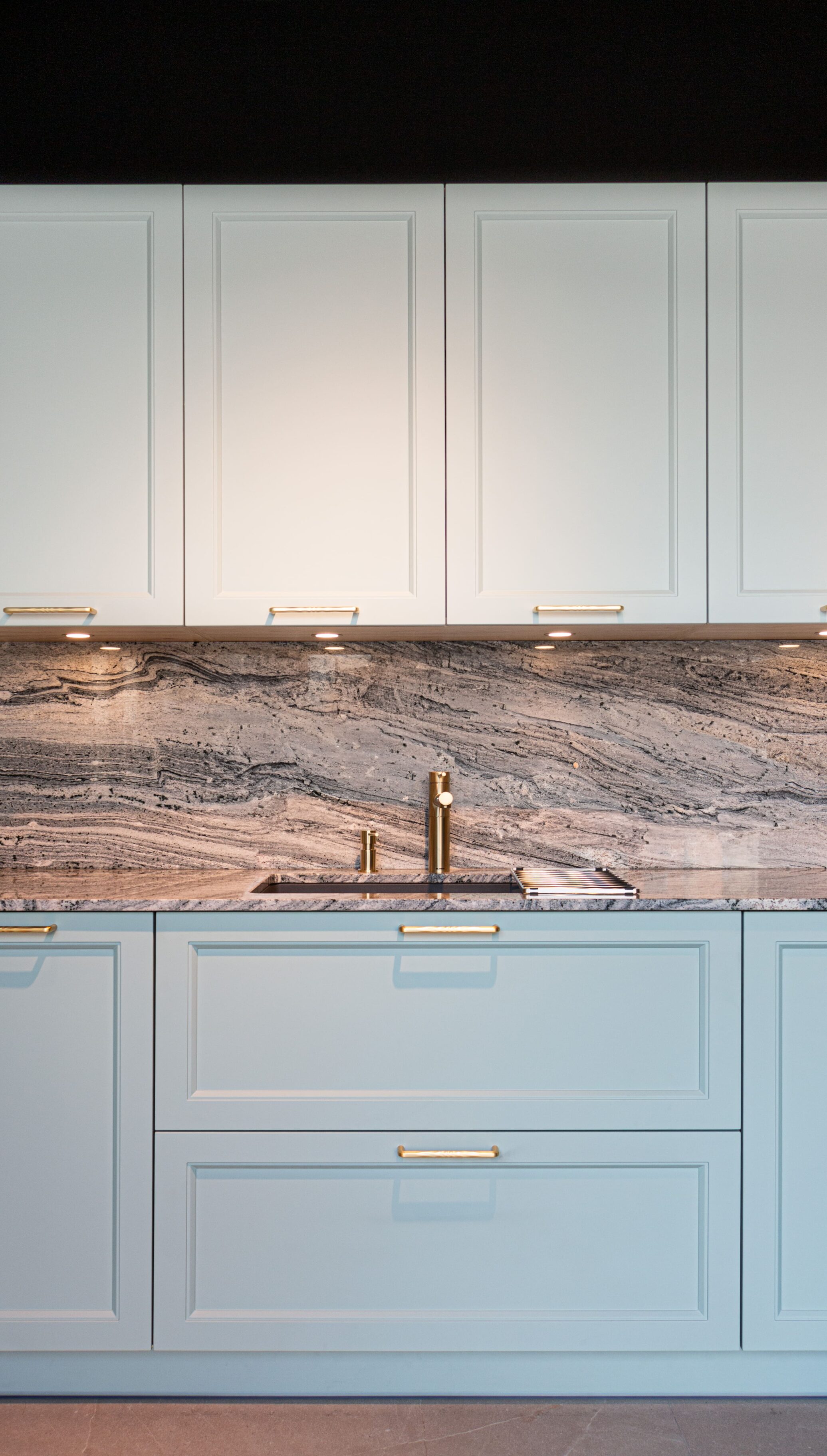Cocina con muebles bajos en azul y encimera de mármol