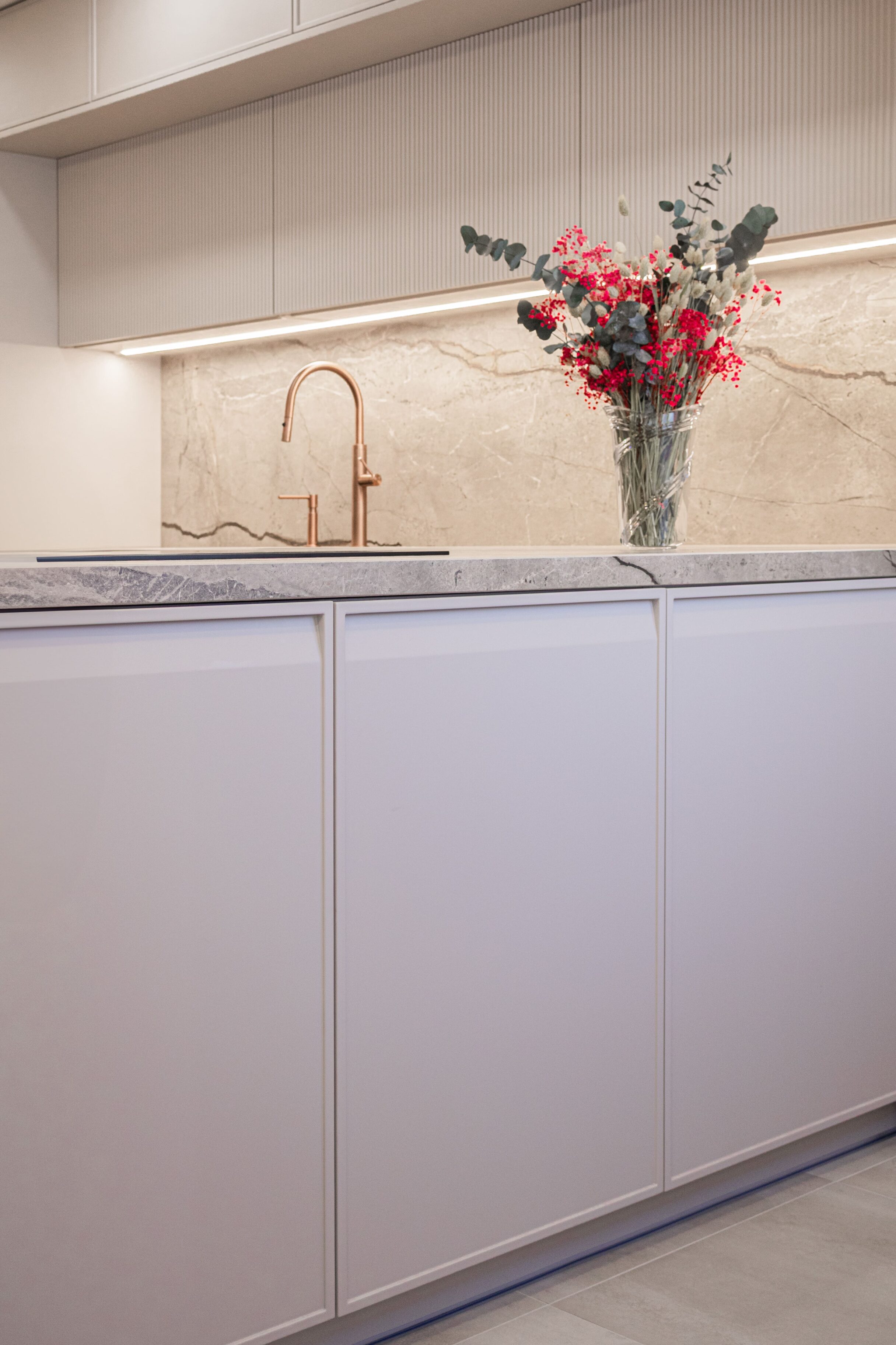 Cocina moderna con muebles blancos y encimera de mármol