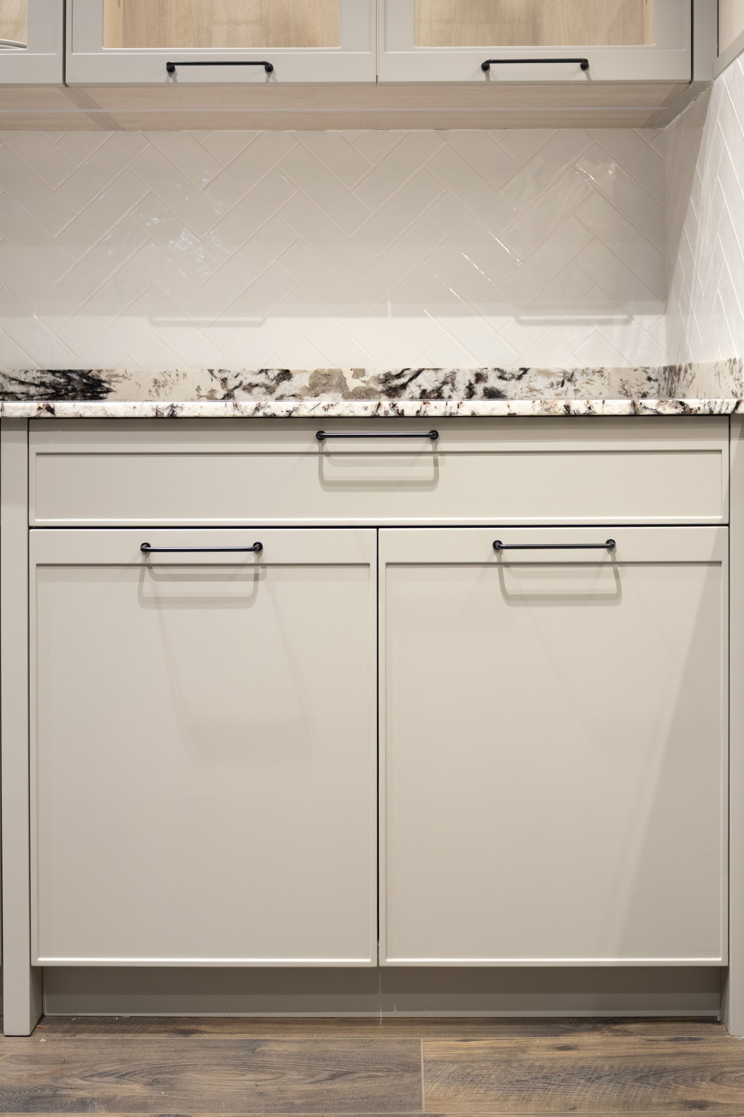 Muebles de cocina en tonos claros con encimera de mármol negro y blanco