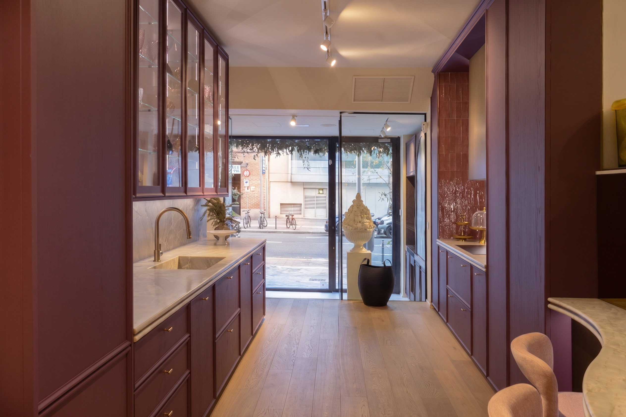 Cocina con mobiliario de color púrpura y encimera de mármol blanco