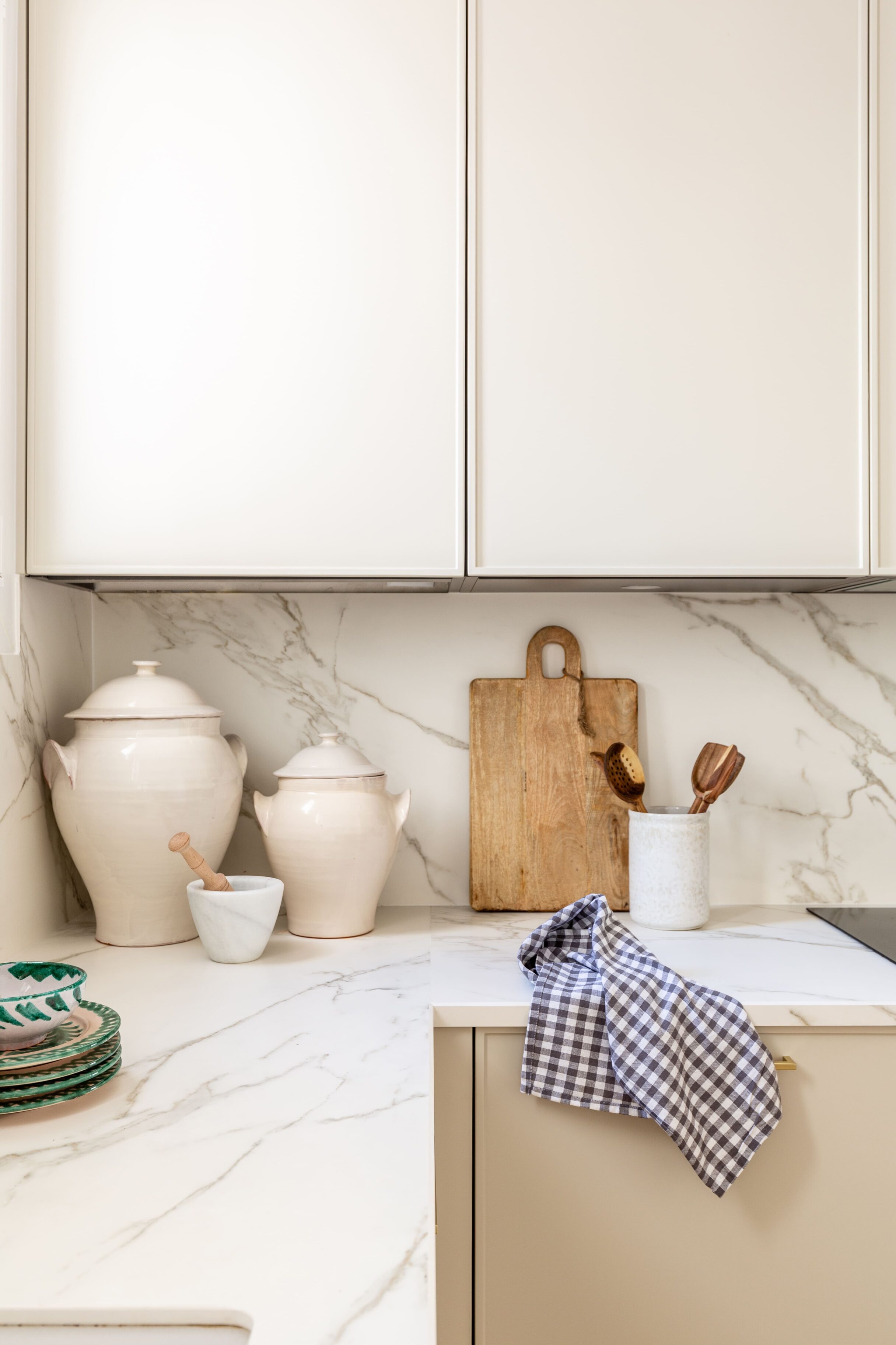 Encimera de mármol con utensilios de cocina y decoración en una cocina contemporánea