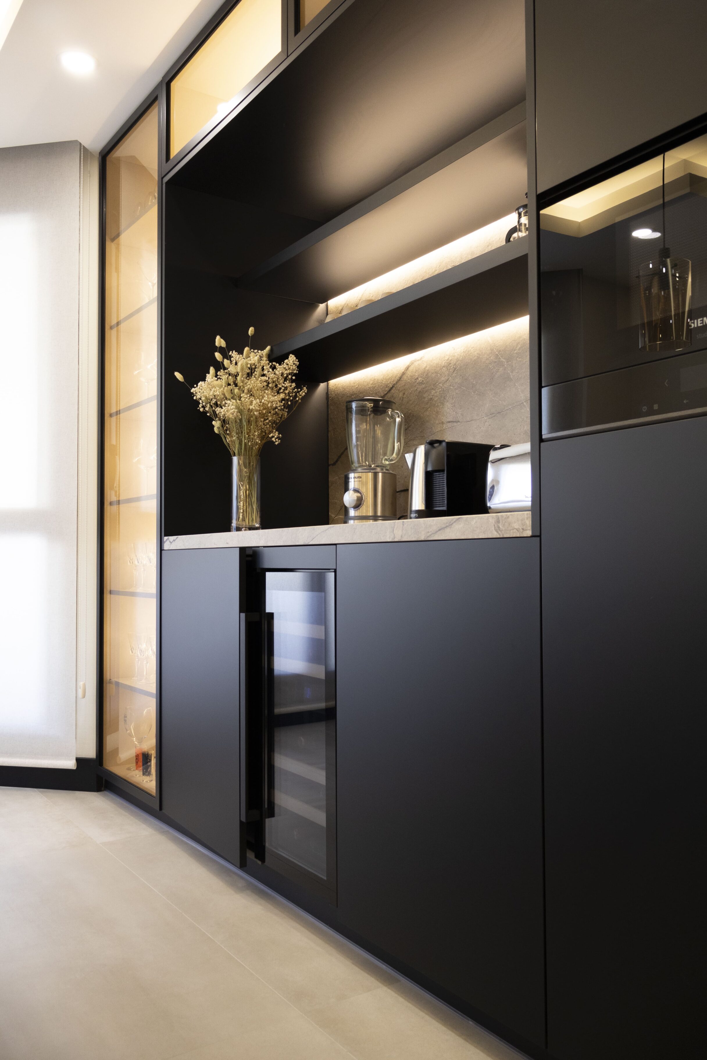 Mueble de cocina negro con encimeras y electrodomésticos integrados