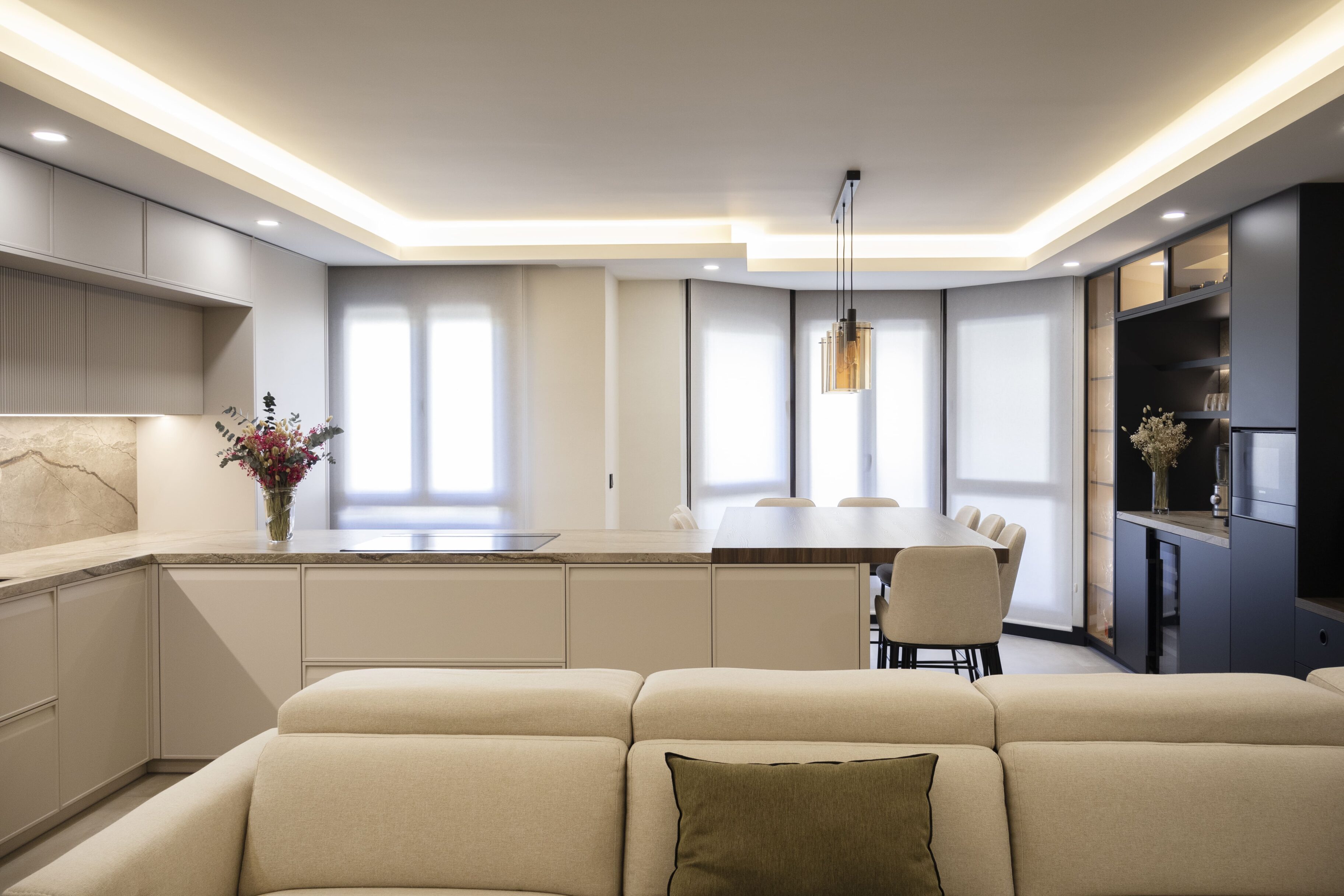 Cocina contemporánea con mobiliario claro, islas y zona de comedor iluminada