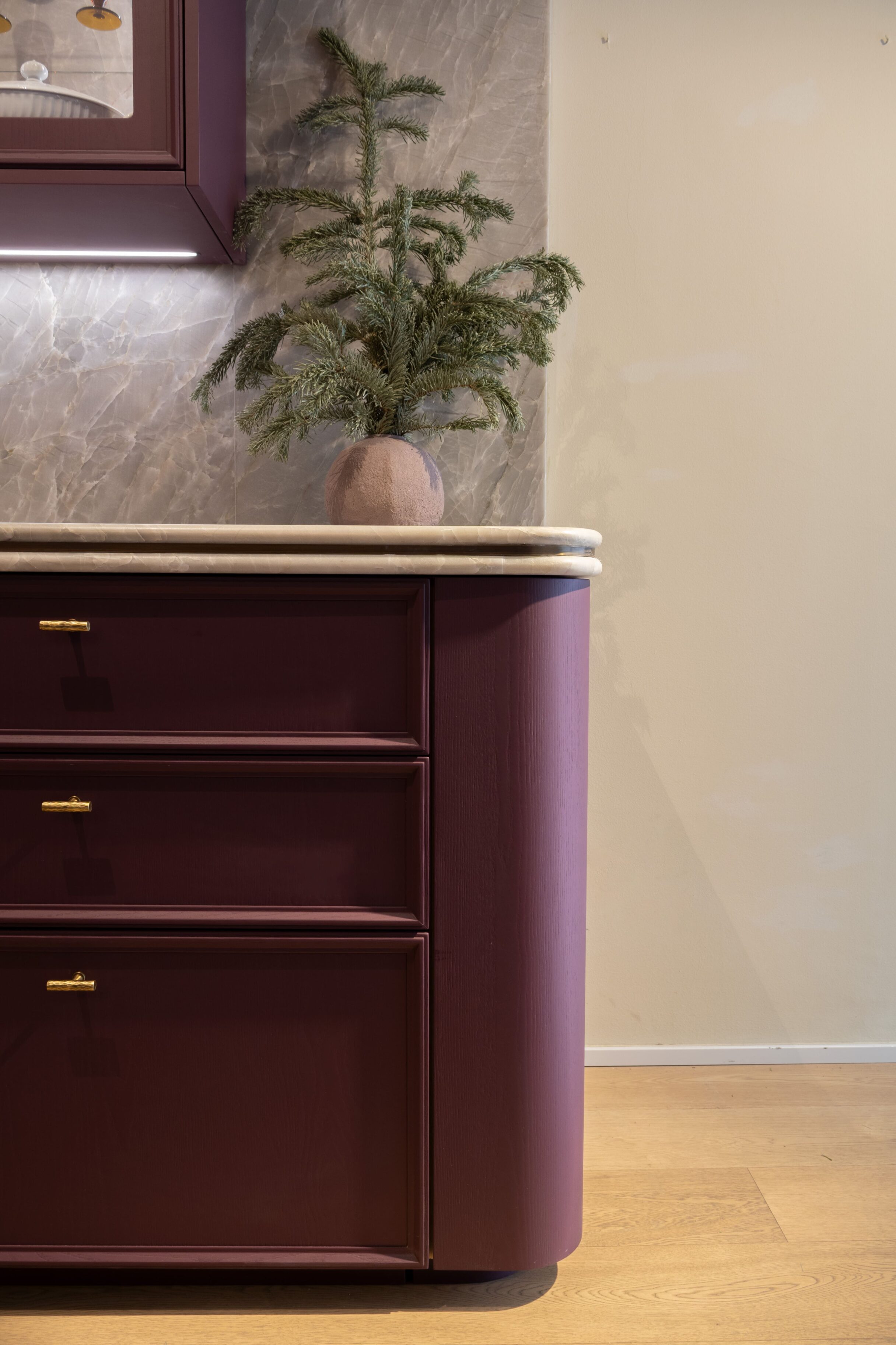Mueble de cocina burdeos con encimera de mármol y decoración vegetal