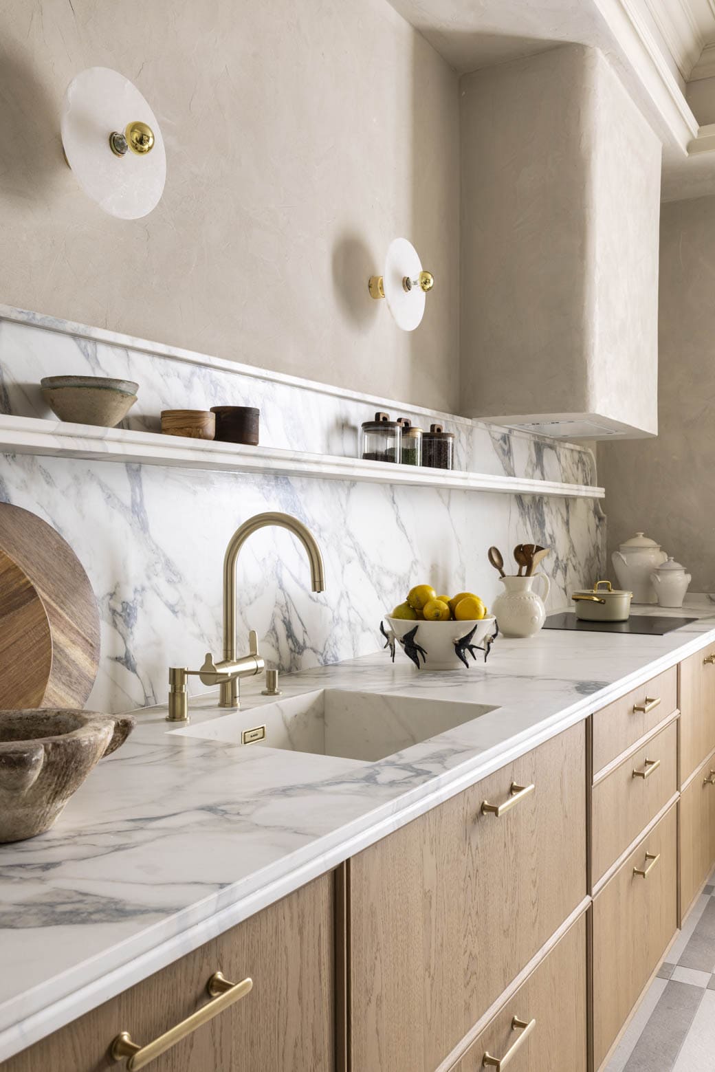 Cocina con encimera de mármol, grifo dorado y detalles en madera