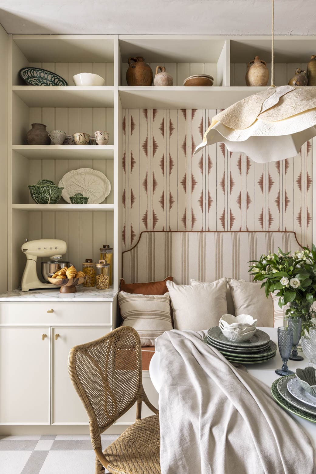 Mesa de comedor decorada con platos y flores en ambiente moderno