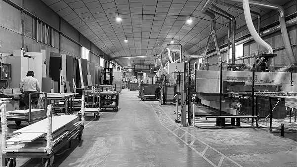 Interior de una fábrica con máquinas y tablones para la fabricación de muebles de cocina